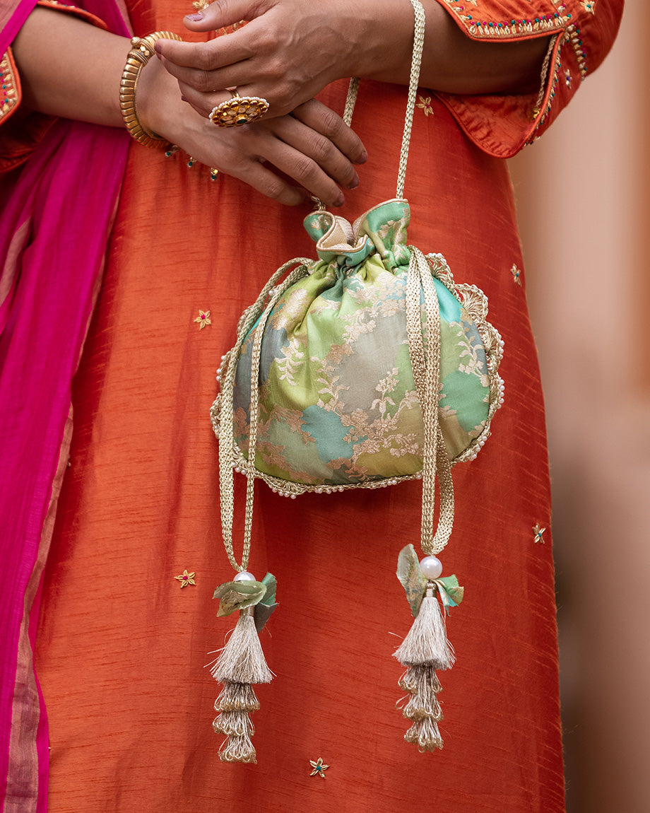 Make a statement with our abstract Banarasi silk potli embellished with pearls and layered silk tassels - the perfect add-on to your look