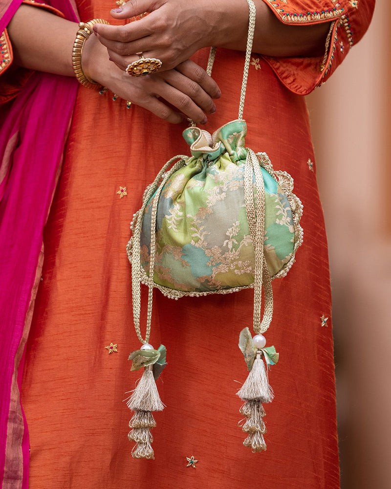 Make a statement with our abstract Banarasi silk potli embellished with pearls and layered silk tassels - the perfect add-on to your look