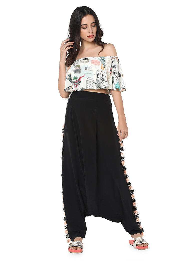 Model wearing Cafe Morocco print off shoulder ruffle top and black low crotch pants